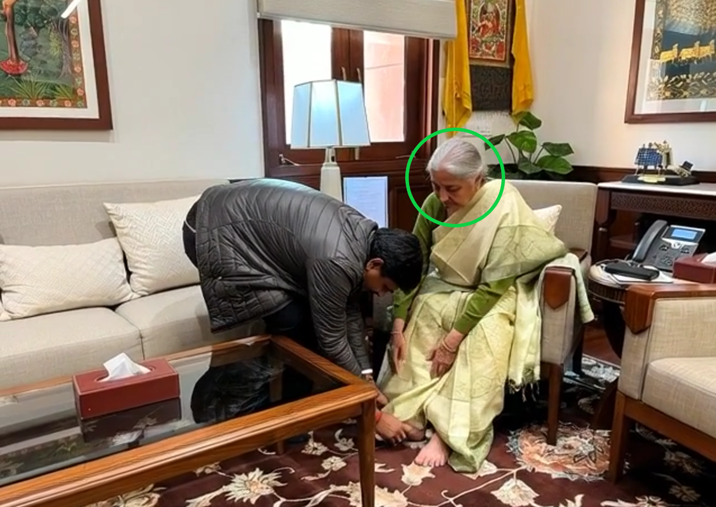 அமைச்சர் நேருவின் மகன் நிர்மலா சீதாராமனின் காலில் விழுந்தார்.